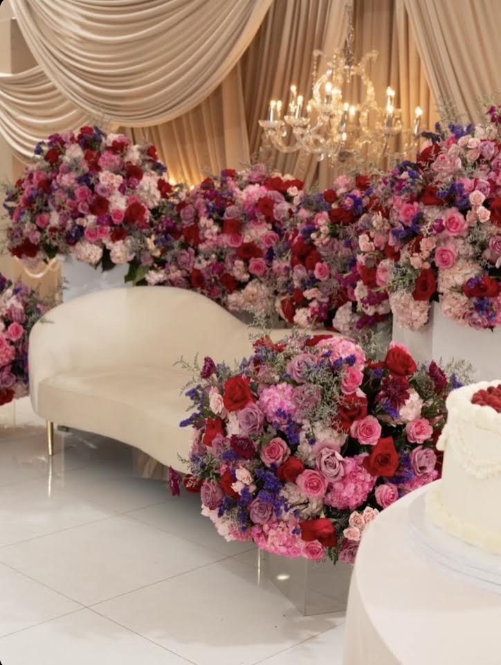 Pink and red roses beside a curved sofa